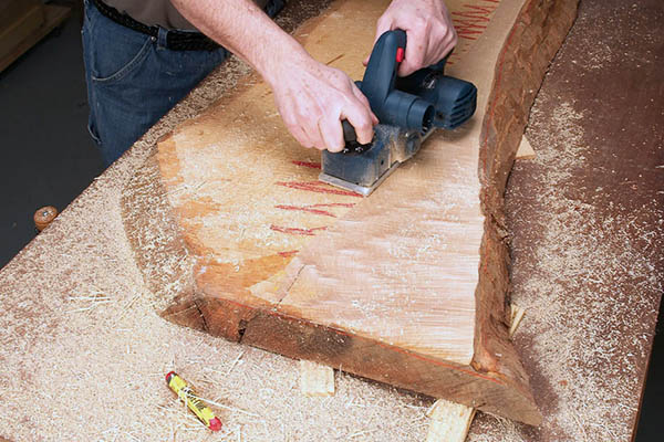 плотник строгает древесину